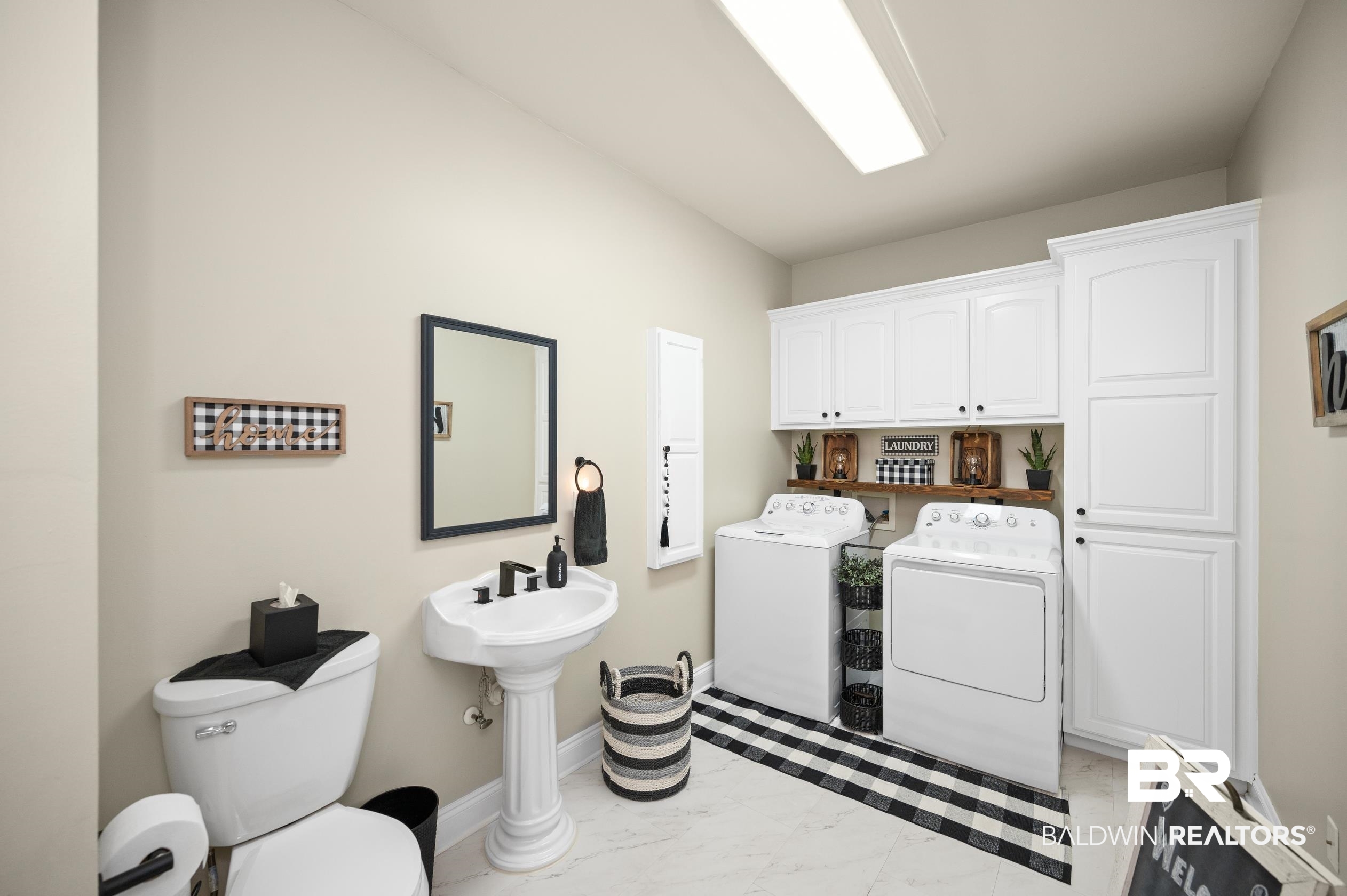 29614 St George Street Daphne, AL 36526 - Photo 32 of 42 Washroom with washing machine and clothes dryer, cabinets, and light tile patterned floors