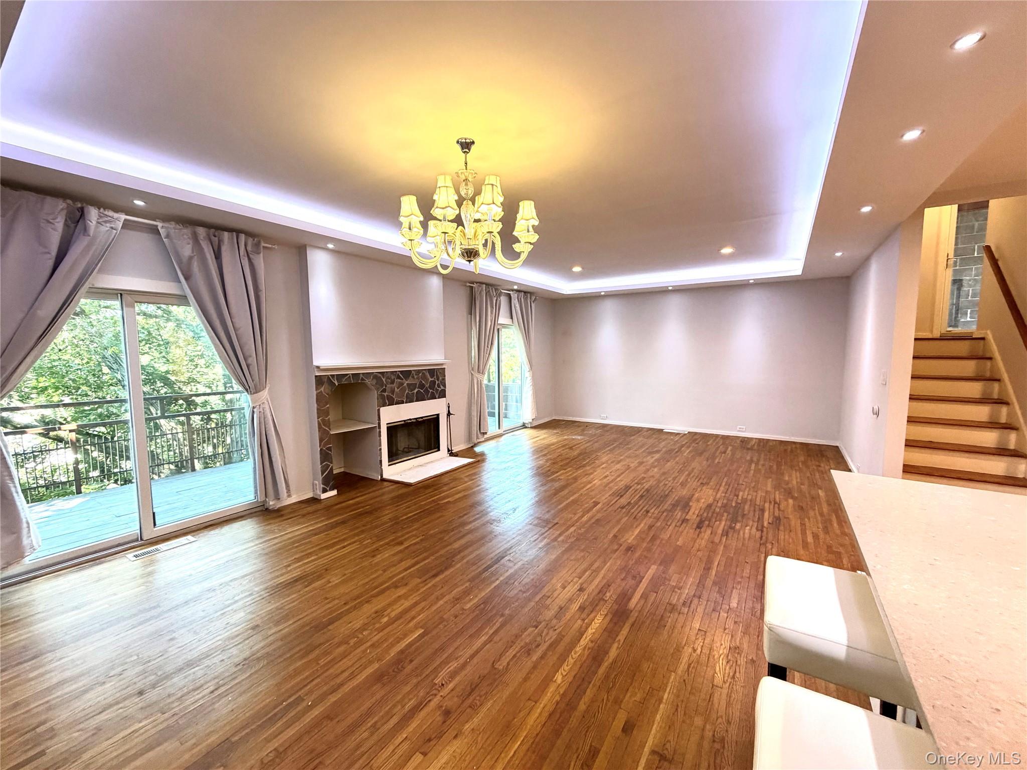 77 Sands Point Road, Unit #1 Port Washington, NY 11050 - Photo 4 of 19 Spacious living area featuring wood-finish flooring, a fireplace with integrated shelving, and recessed lighting