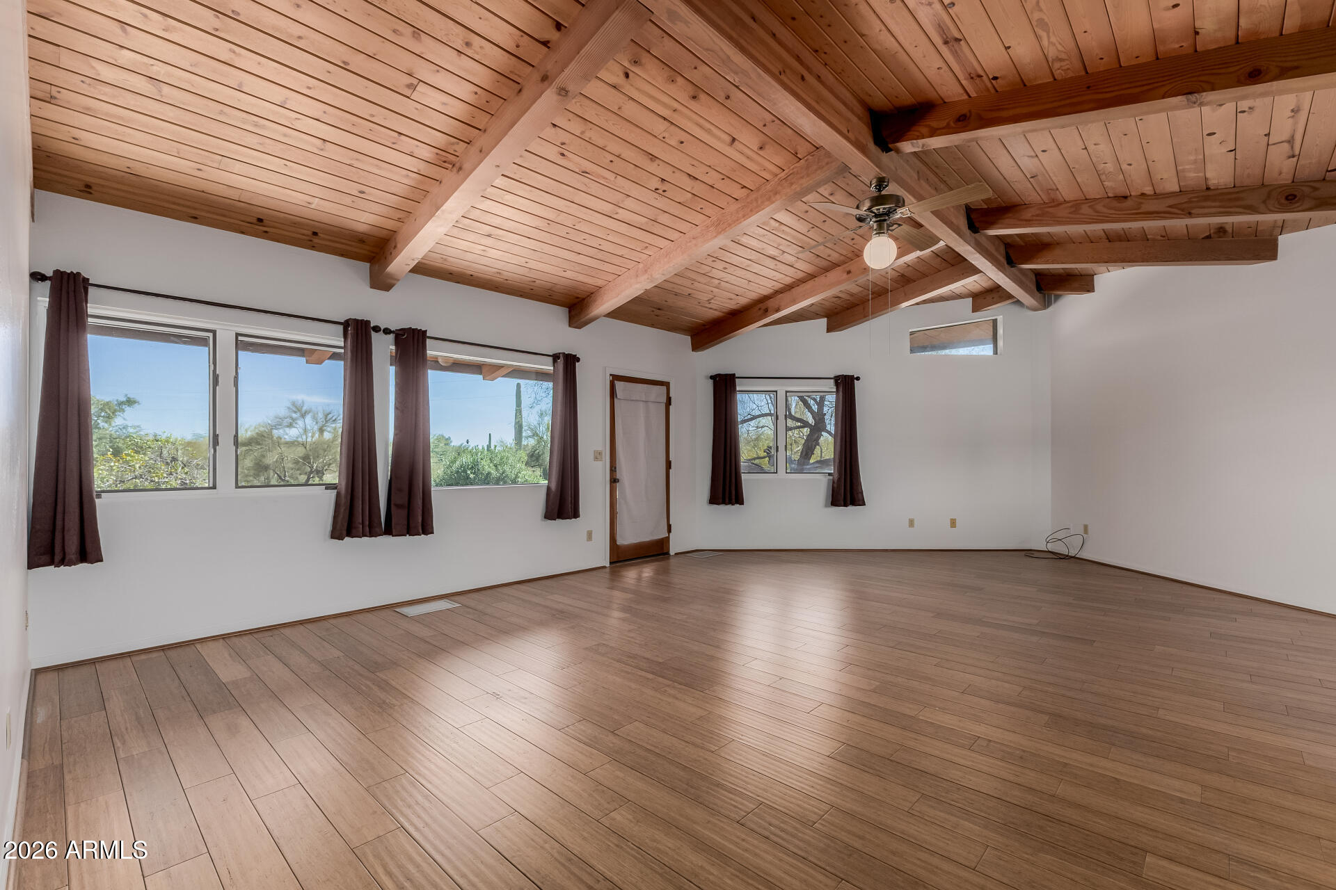 6140 East Peak View Road Cave Creek, AZ 85331 - Photo 12 of 52 a view of an empty room with wooden floor and a window