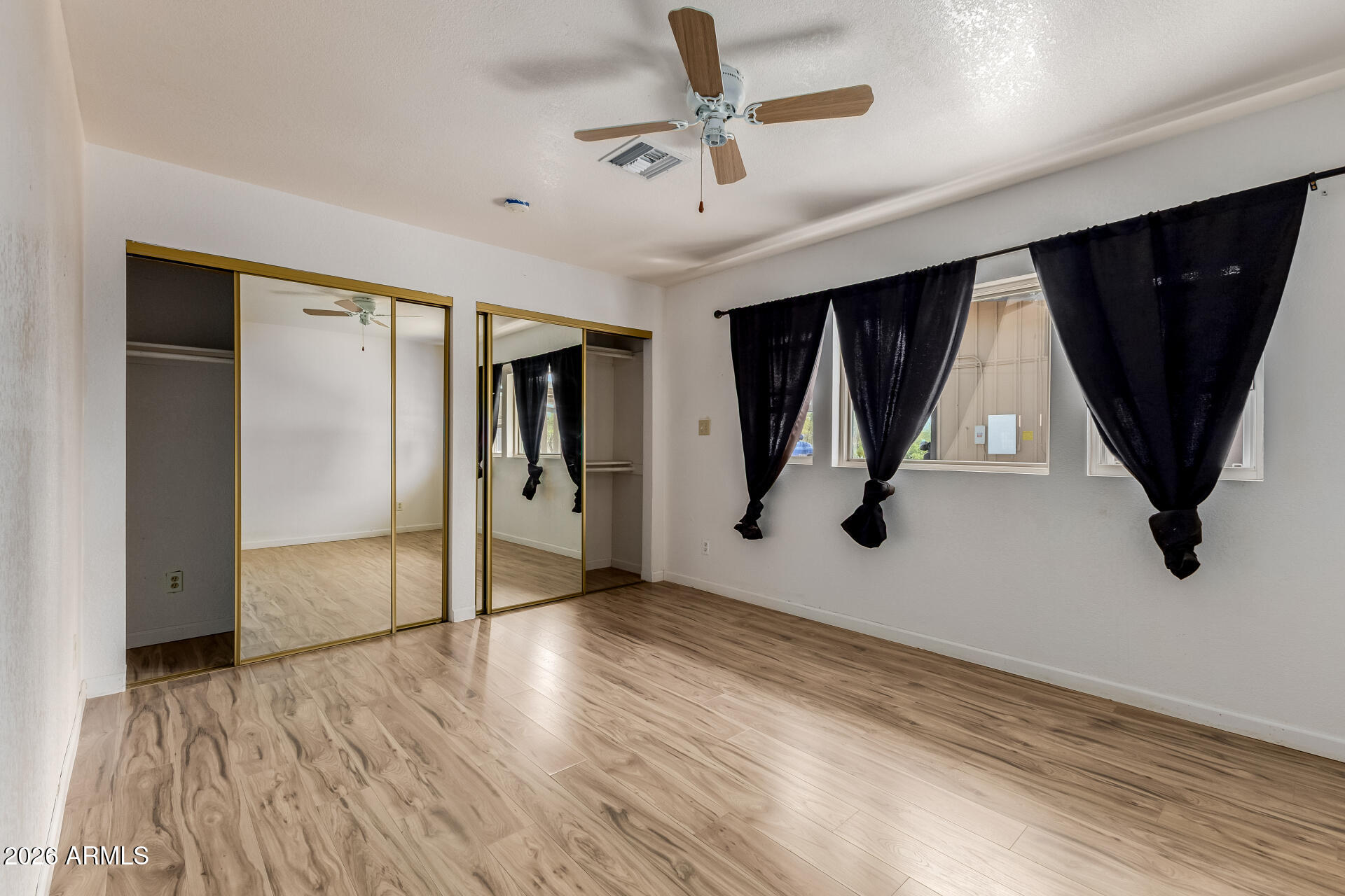 6140 East Peak View Road Cave Creek, AZ 85331 - Photo 31 of 52 a view of an empty room with wooden floor and a window