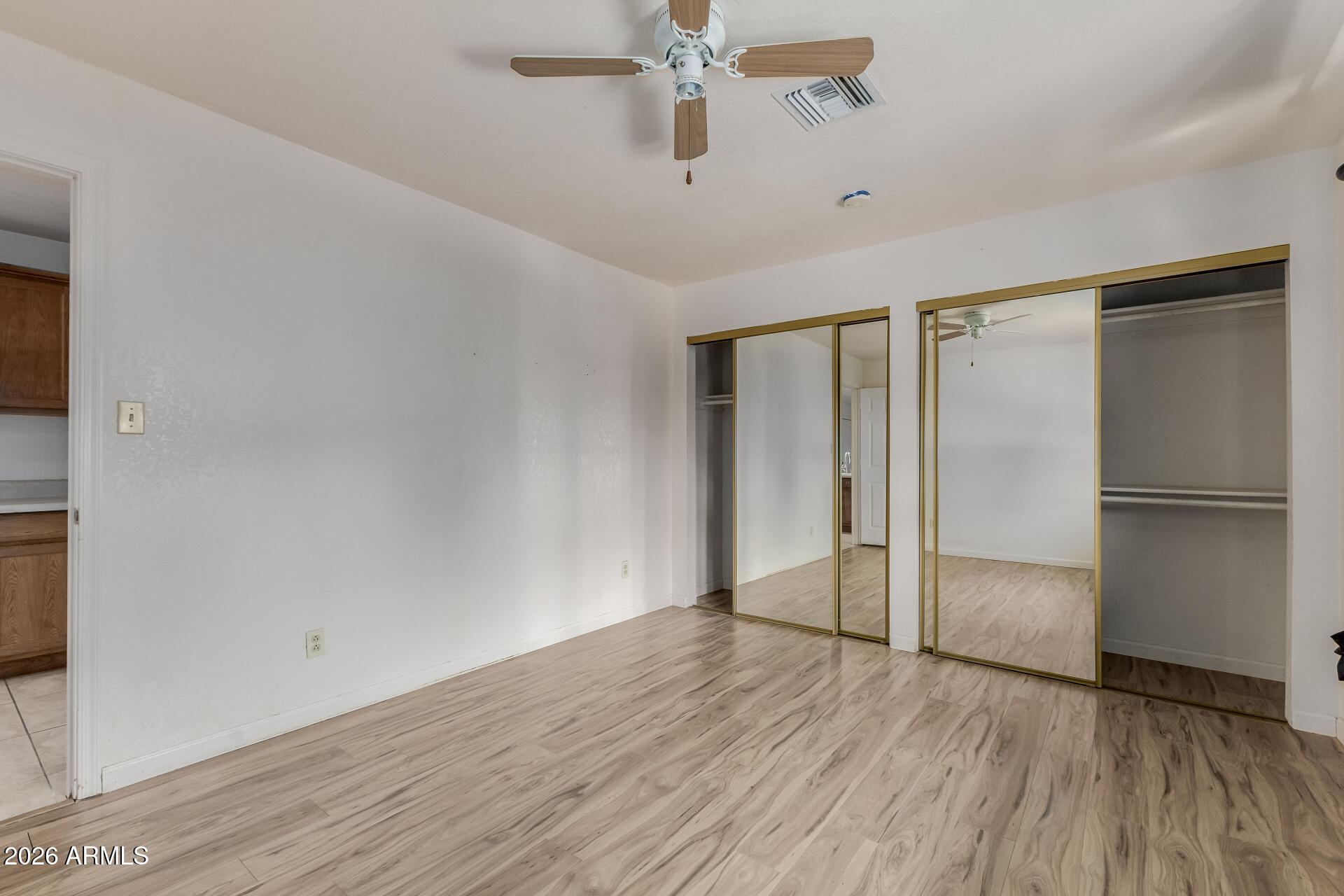 6140 East Peak View Road Cave Creek, AZ 85331 - Photo 32 of 52 a view of an empty room with wooden floor and a ceiling fan