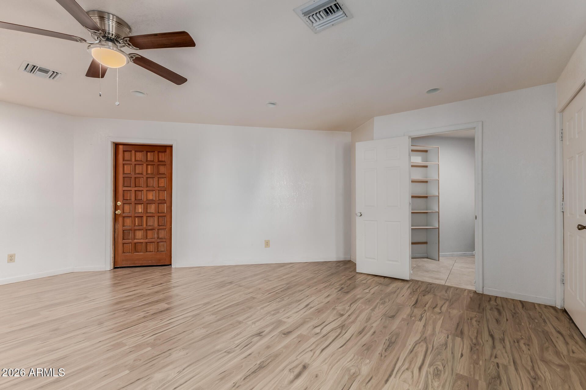6140 East Peak View Road Cave Creek, AZ 85331 - Photo 33 of 52 an empty room with wooden floor ceiling fan and windows