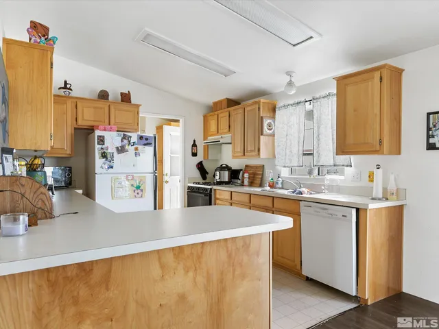 a kitchen that has a lot of cabinets a sink and a wooden floor