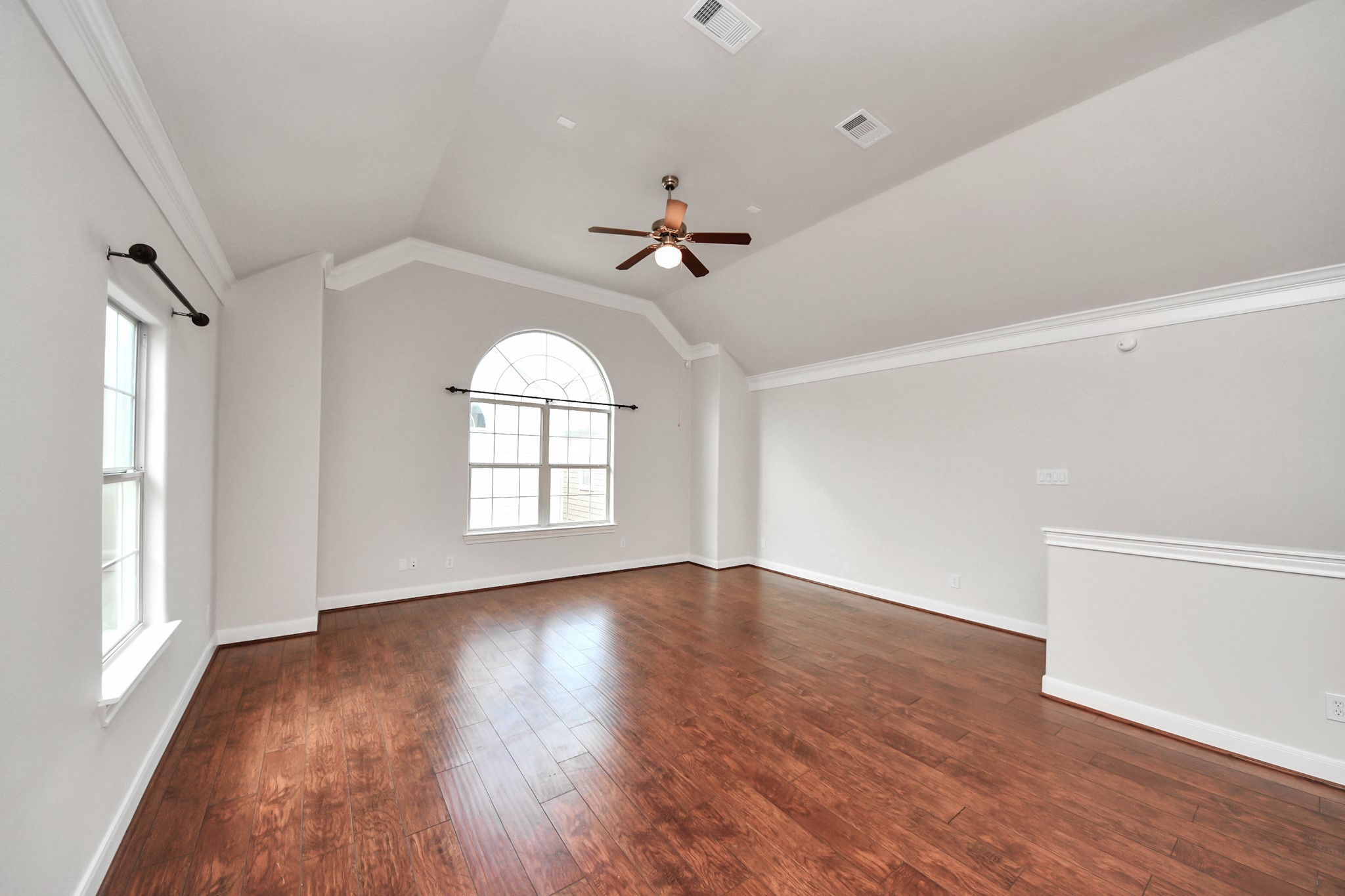 2941 Clinton Drive Houston, TX 77020 - Photo 5 of 35 an empty room with wooden floor ceiling fan and windows