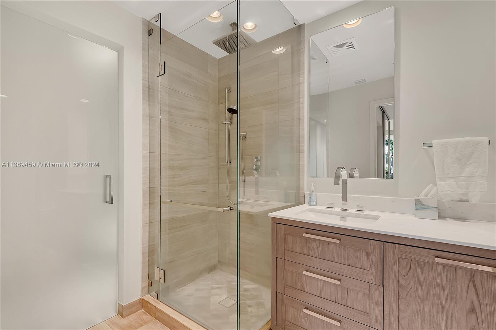 360 Ocean Drive, Unit 205S Key Biscayne, FL 33149 - Photo 12 of 27 a bathroom with a shower sink and mirror