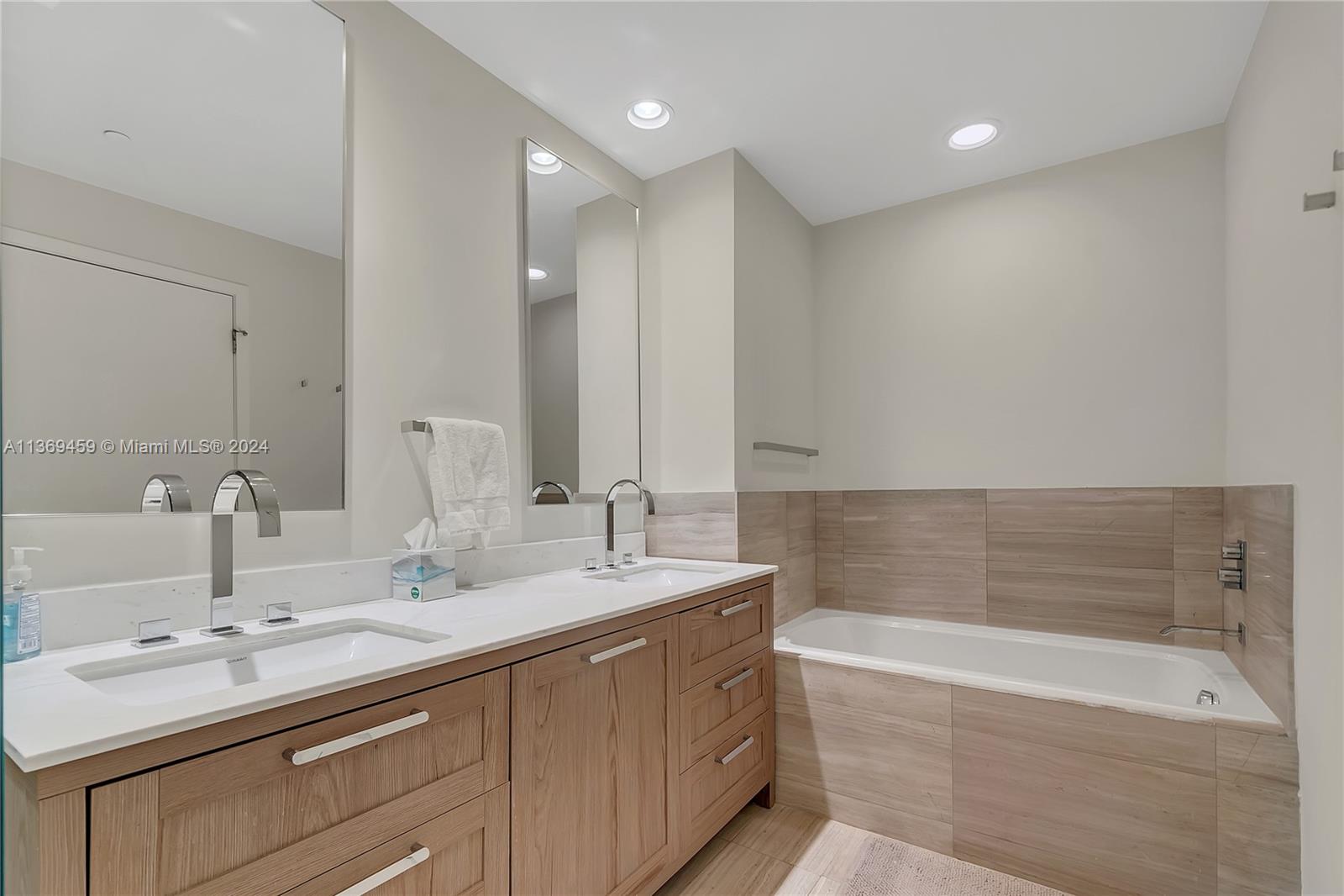 360 Ocean Drive, Unit 205S Key Biscayne, FL 33149 - Photo 13 of 27 a bathroom with a double vanity sink and a bathtub