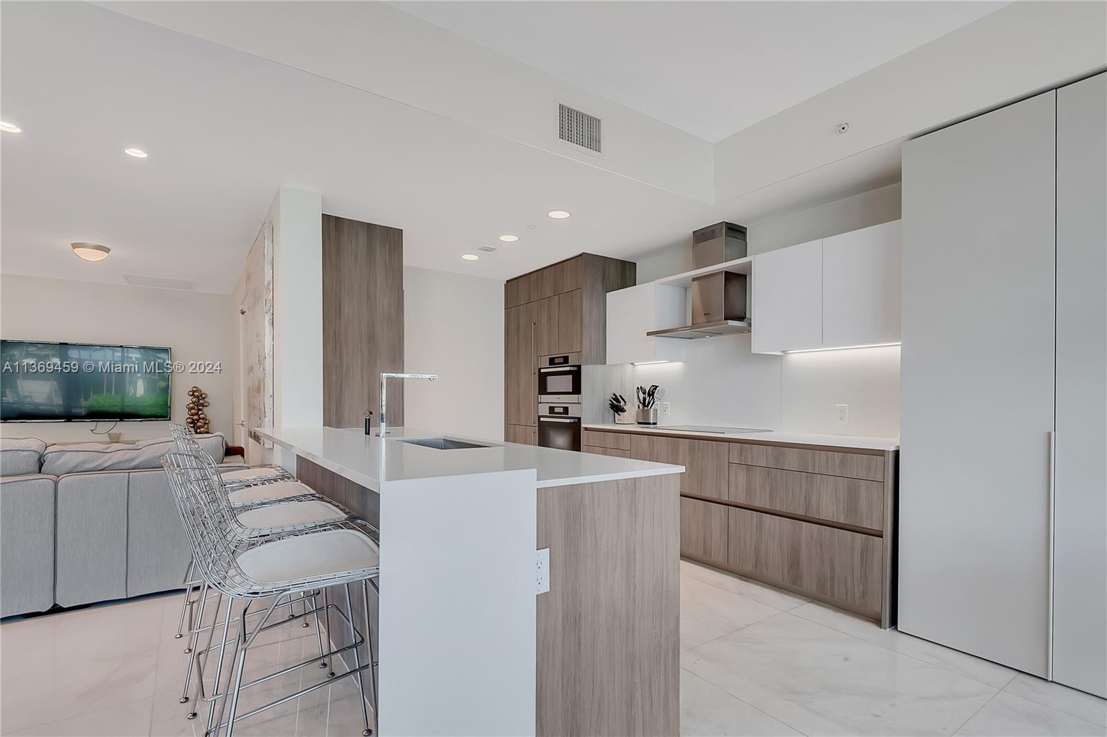 360 Ocean Drive, Unit 205S Key Biscayne, FL 33149 - Photo 7 of 27 a large white kitchen with cabinets