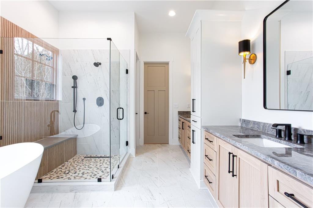3286 Elwin Ragsdale Way Acworth, GA 30102 - Photo 39 of 51 a bathroom with a granite countertop sink a mirror a bathtub and a shower