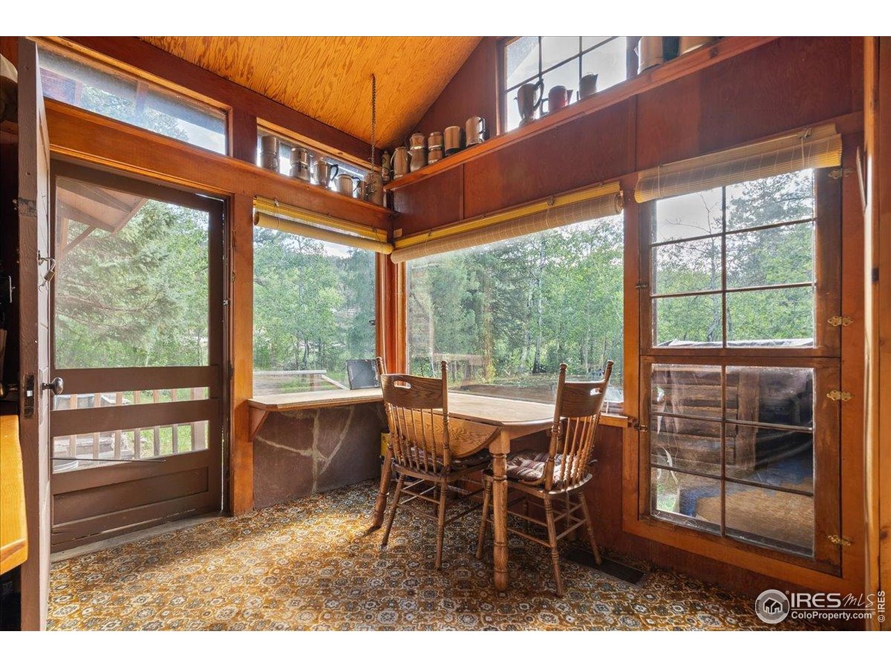 49 Riverside Drive Lyons, CO 80540 - Photo 16 of 32 a dining room with wooden floor and outdoor seating