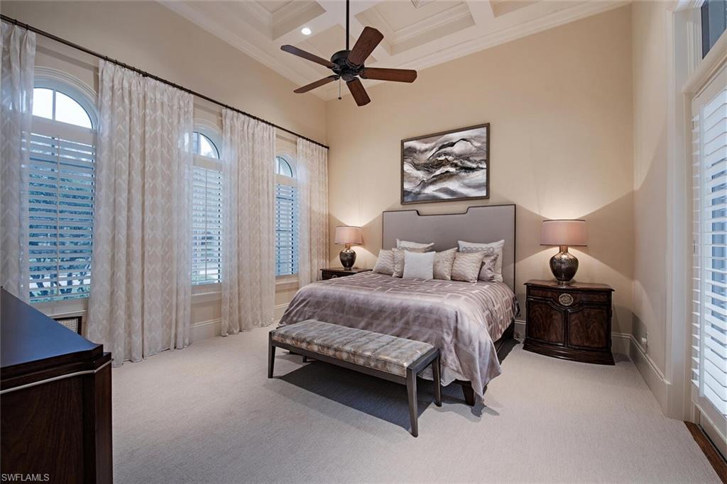 14919 Celle Way Naples, FL 34110 - Photo 13 of 42 a spacious bedroom with a bed and a chandelier