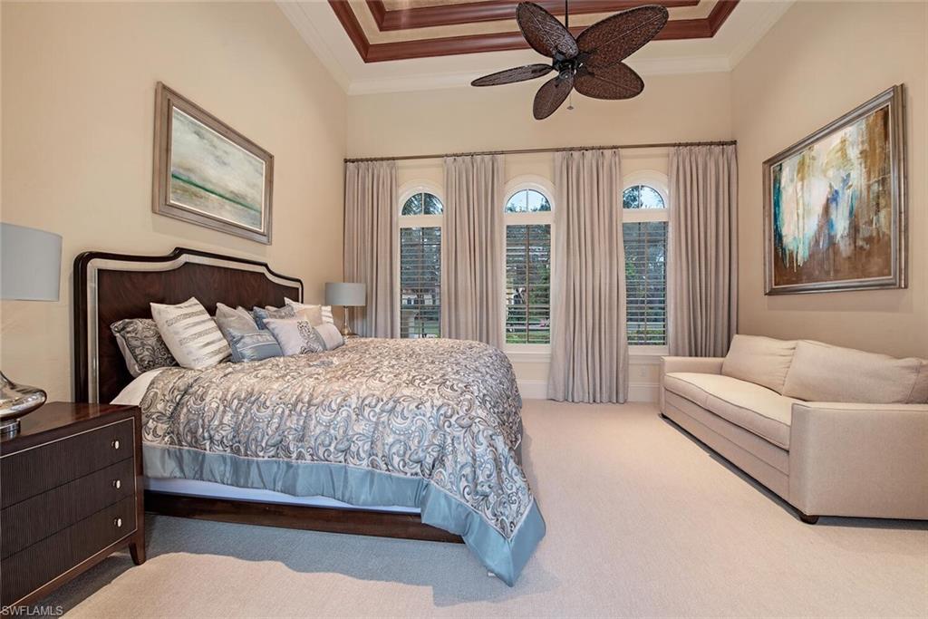 14919 Celle Way Naples, FL 34110 - Photo 14 of 42 a bedroom with a large bed and a chandelier