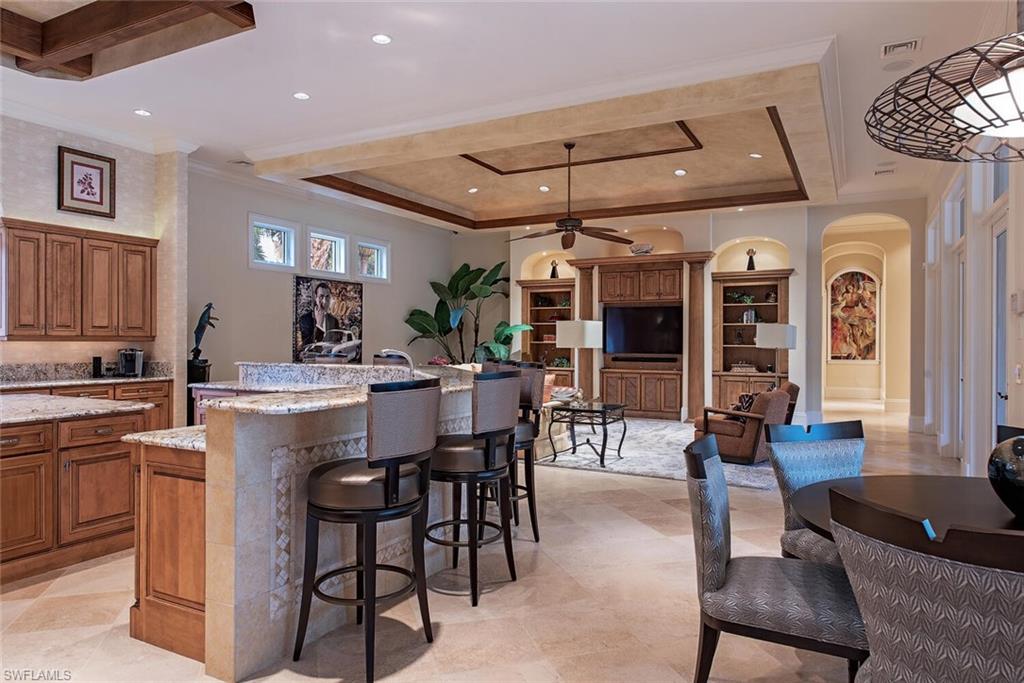 14919 Celle Way Naples, FL 34110 - Photo 3 of 42 a kitchen with stainless steel appliances kitchen island granite countertop a table and chairs in it