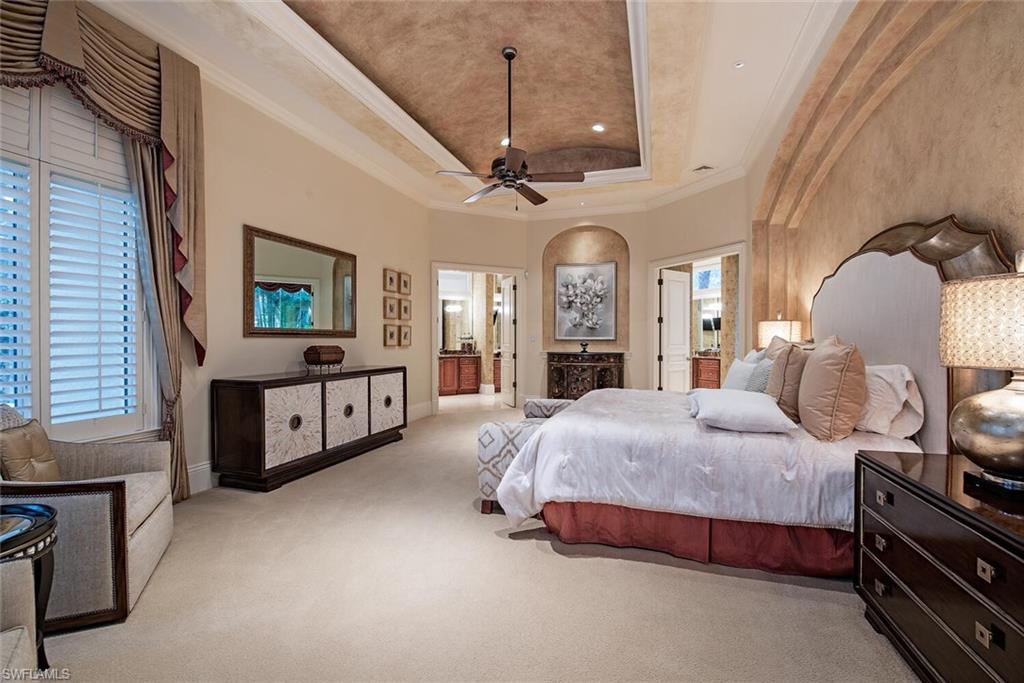 14919 Celle Way Naples, FL 34110 - Photo 8 of 42 a spacious bedroom with a bed a chandelier and dresser