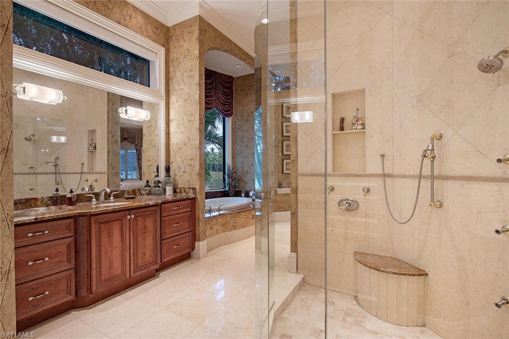 14919 Celle Way Naples, FL 34110 - Photo 10 of 42 a spacious bathroom with a granite countertop sink mirror and shower