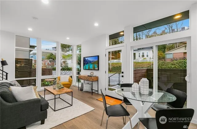 a dining room with furniture a table and a large window