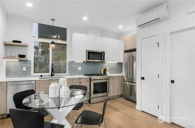 a kitchen with stainless steel appliances granite countertop a stove top oven a sink and a refrigerator