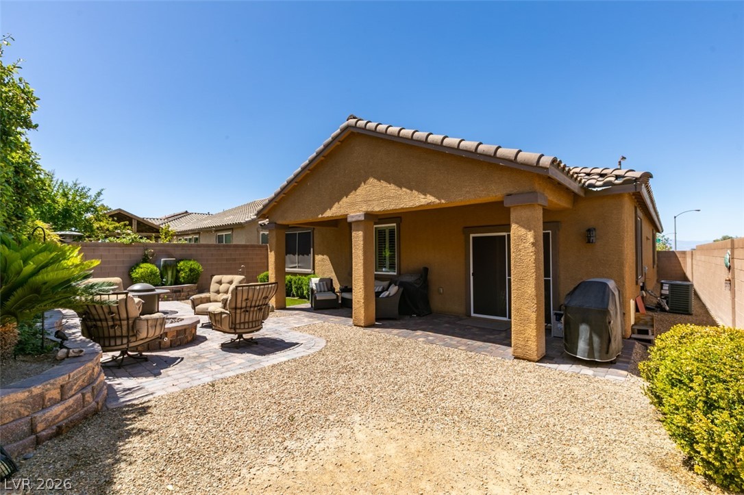 7375 Campbell Ranch Avenue Las Vegas, NV 89179 - Photo 34 of 45 An inviting backyard oasis offers both covered patio lounging and an open-air fire pit seating area.