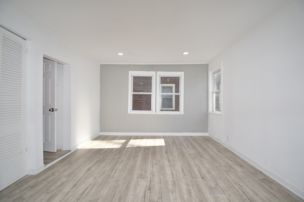 79 Quincy Street Springfield, MA 01109 - Photo 11 of 27 a view of an empty room with wooden floor and a window