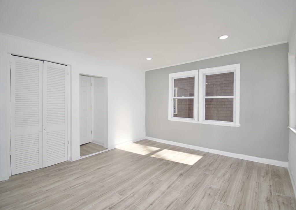 79 Quincy Street Springfield, MA 01109 - Photo 12 of 27 a view of an empty room with wooden floor and a window