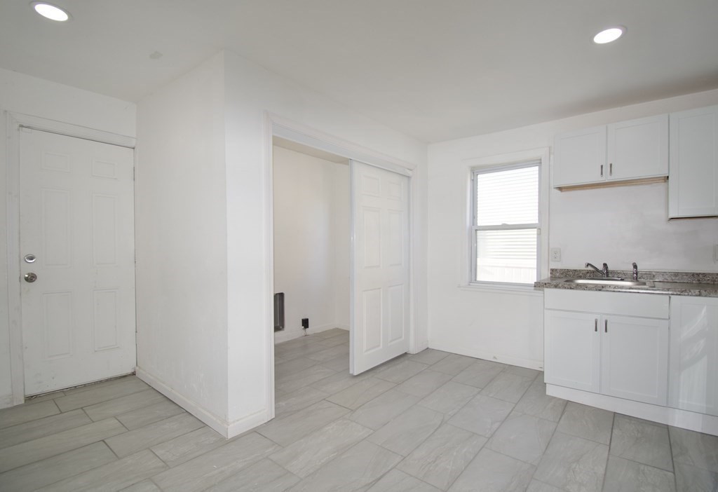 79 Quincy Street Springfield, MA 01109 - Photo 6 of 27 a kitchen with granite countertop white cabinets and white appliances