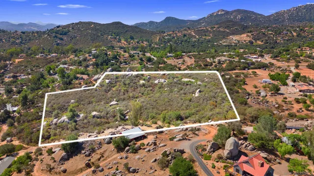 an aerial view of residential houses with outdoor space and trees