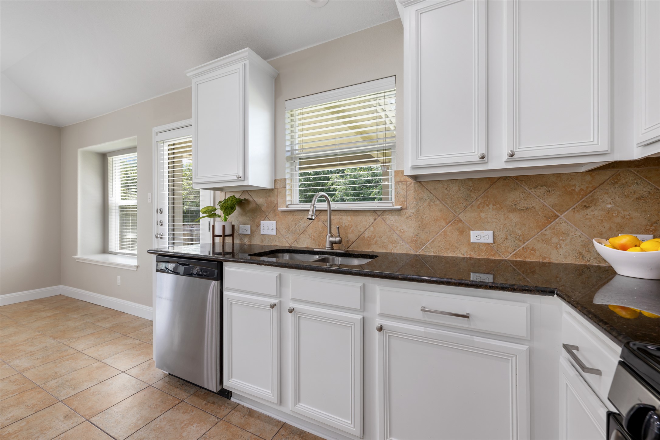 18820 Edinburgh Castle Road Pflugerville, TX 78660 - Photo 11 of 37 a kitchen with granite countertop white cabinets and window