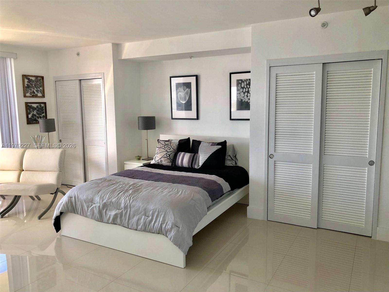 1500 Bay Road, Unit 1236S Miami Beach, FL 33139 - Photo 5 of 24 a bedroom with a bed and a couch