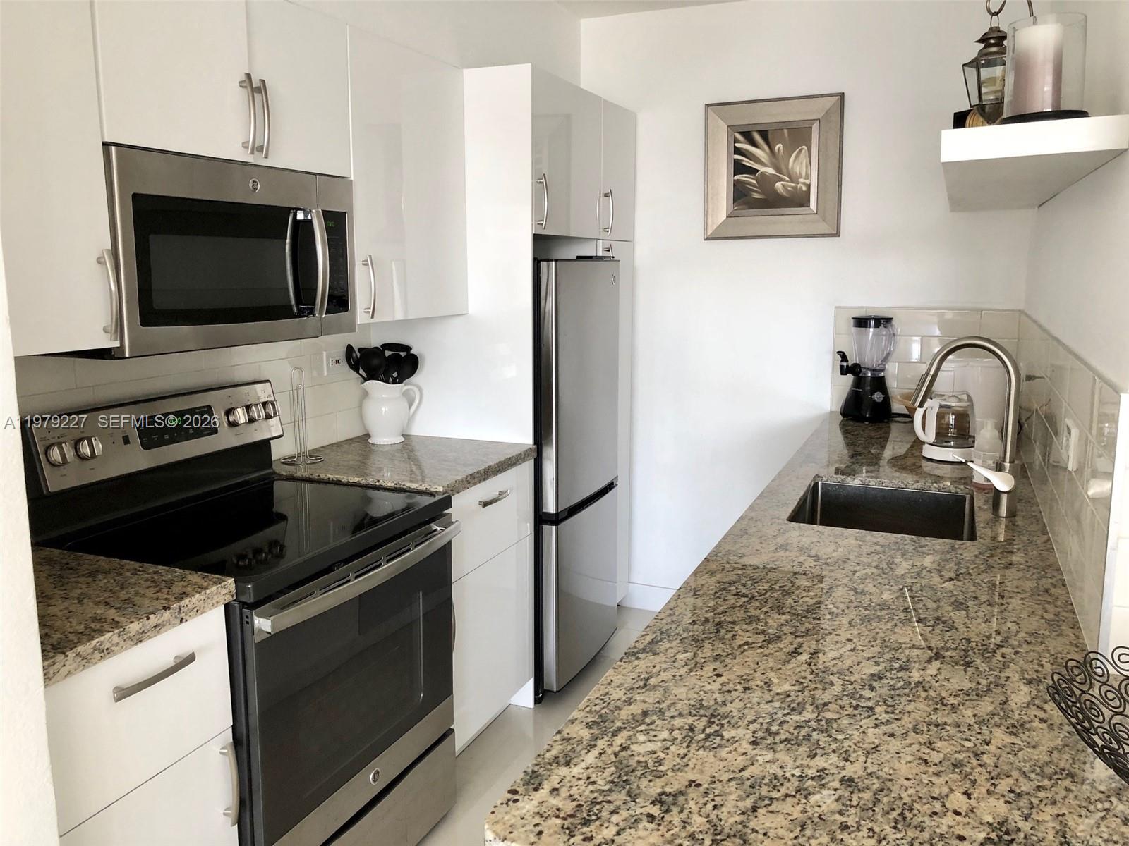 1500 Bay Road, Unit 1236S Miami Beach, FL 33139 - Photo 7 of 24 a kitchen with a stove microwave and sink