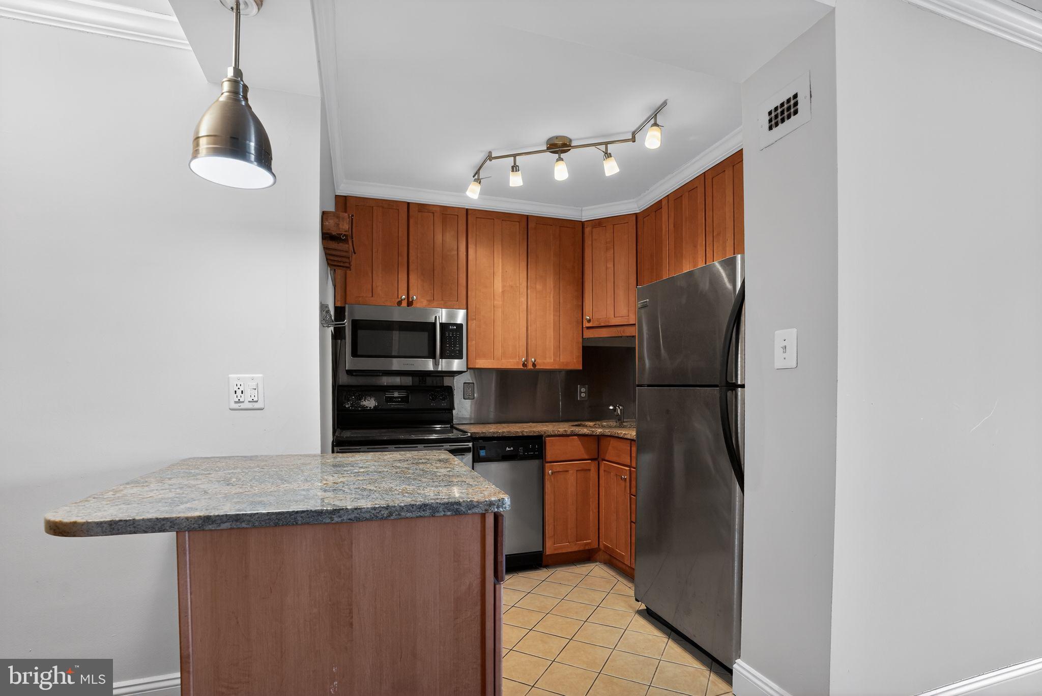 1435 4th Street Southwest, Unit B201 Washington, DC 20024 - Photo 7 of 13 a kitchen with stainless steel appliances granite countertop a refrigerator a stove a sink and a microwave