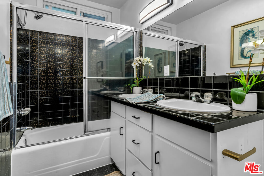 8330 Zitola Terrace Playa del Rey, CA 90293 - Photo 30 of 48 a bathroom with a granite countertop sink a mirror a bathtub and shower