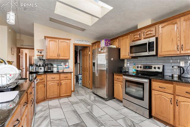 7935 Mohawk Road Colorado Springs, CO 80908 - Photo 7 of 33 Large Kitchen with Stainless Steel Appliances.
