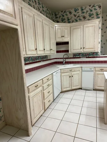 a kitchen with white cabinets and white appliances