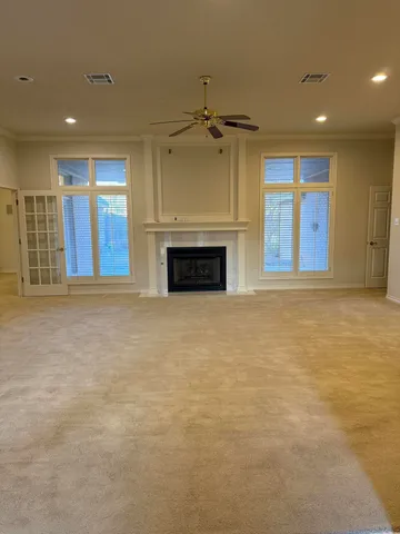 a view of an empty room with a fireplace and a window