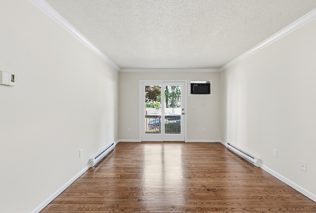 30 Abbey Road, Unit 102 Leominster, MA 01453 - Photo 5 of 15 a view of an empty room with wooden floor and a window