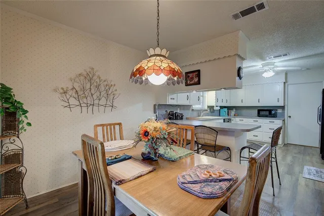 a very nice looking dining room with furniture wooden floor and a chandelier