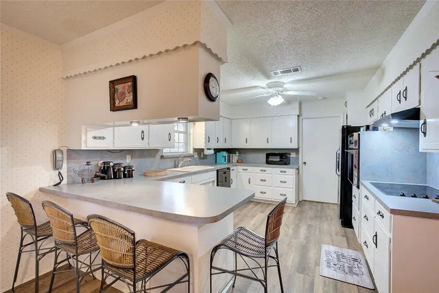 a kitchen with stainless steel appliances kitchen island granite countertop a refrigerator a stove a sink dishwasher with a dining table and chairs