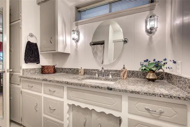 a bathroom with sink granite and mirror