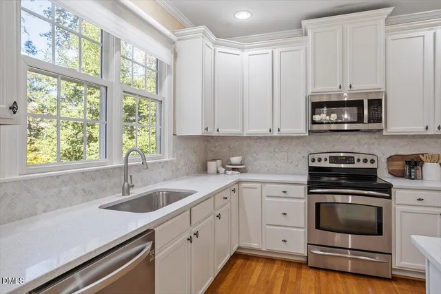 a kitchen with appliances a sink and a window