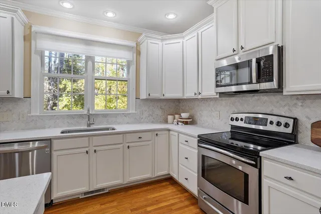 a kitchen with stainless steel appliances granite countertop a stove a sink and a microwave
