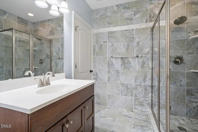 a bathroom with a sink mirror and shower