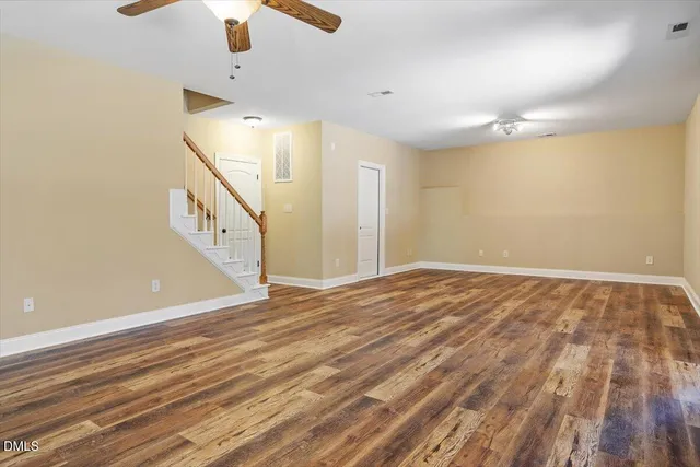 an empty room with ceiling fan and window