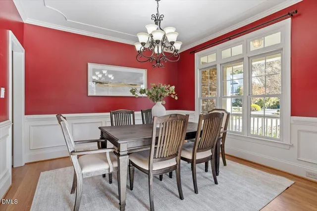 a view of a dining room with furniture a chandelier and wooden floor