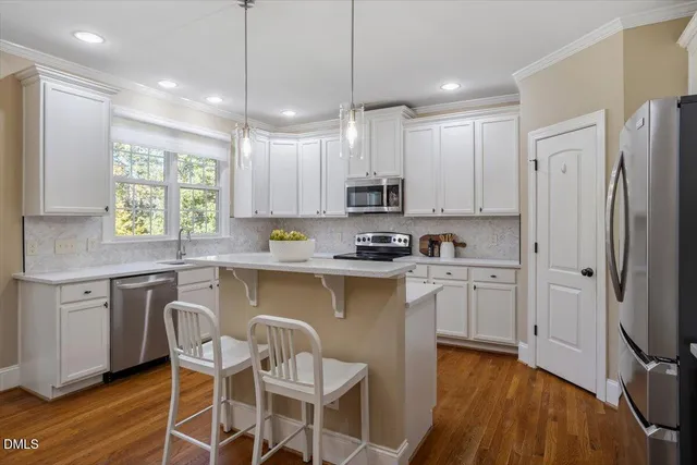 a kitchen with kitchen island granite countertop a sink cabinets and wooden floor