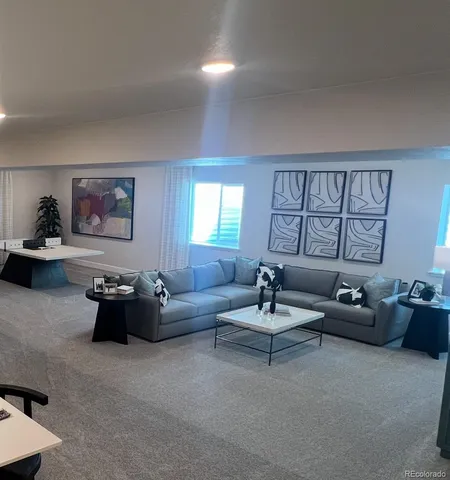 a living room with furniture kitchen view and a window