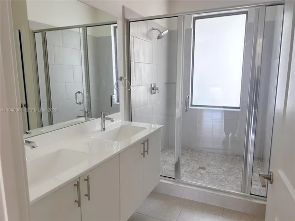 a bathroom with a shower sink and mirror
