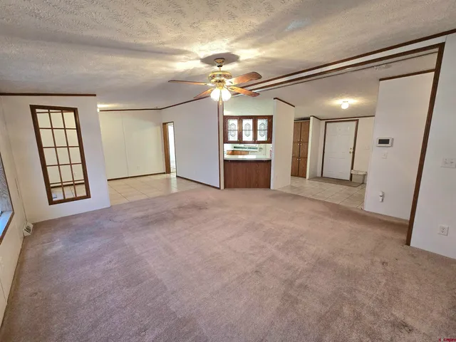 en empty room with windows and ceiling fan