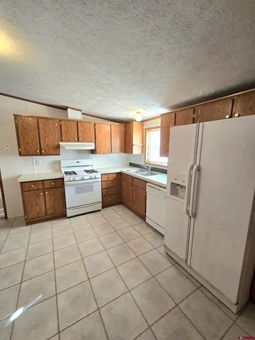 a kitchen with stainless steel appliances granite countertop a refrigerator sink and cabinets