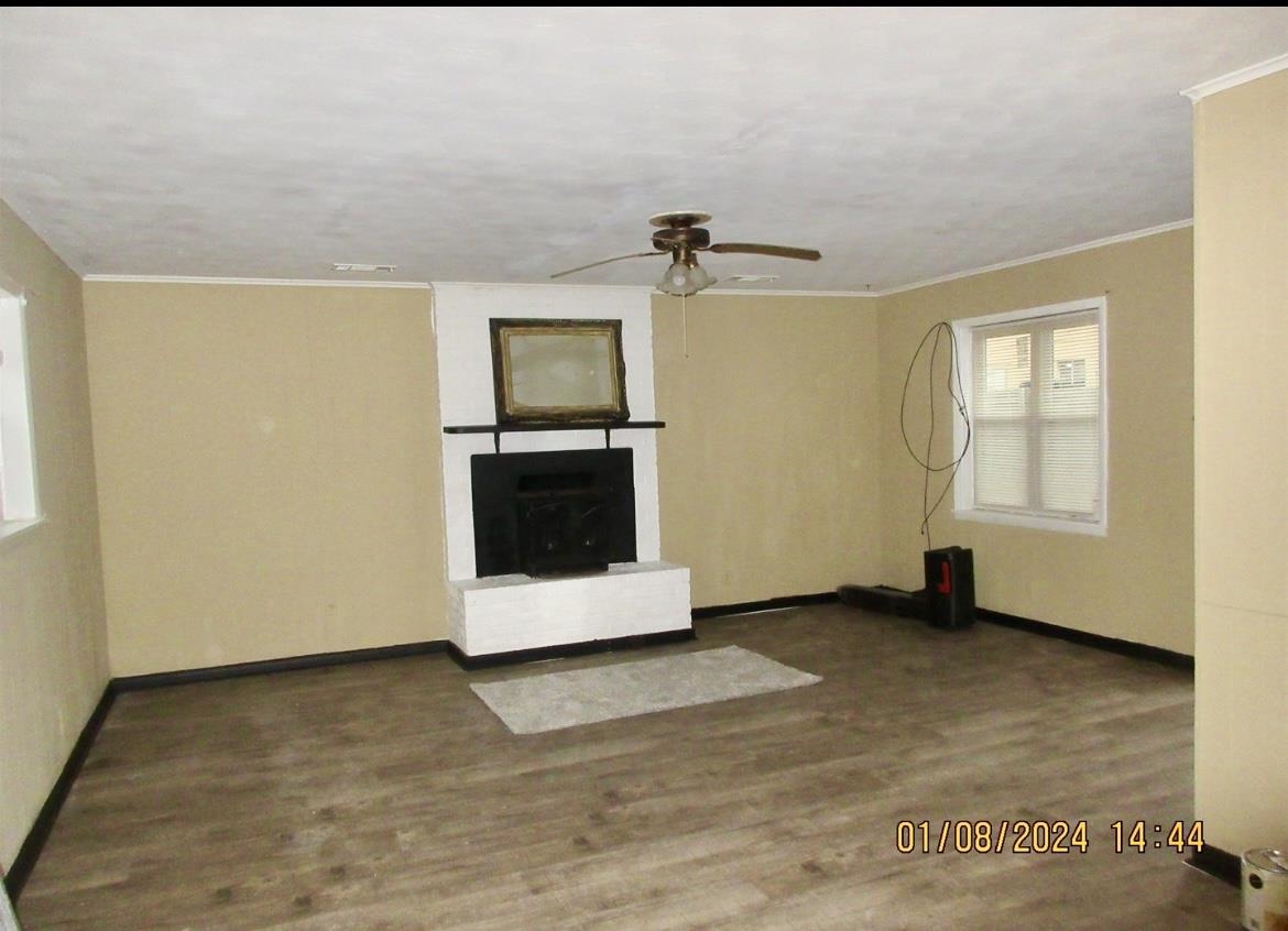 493 Perkins Street Ripley, TN 38063 - Photo 4 of 12 a view of an empty room with a fireplace and a window