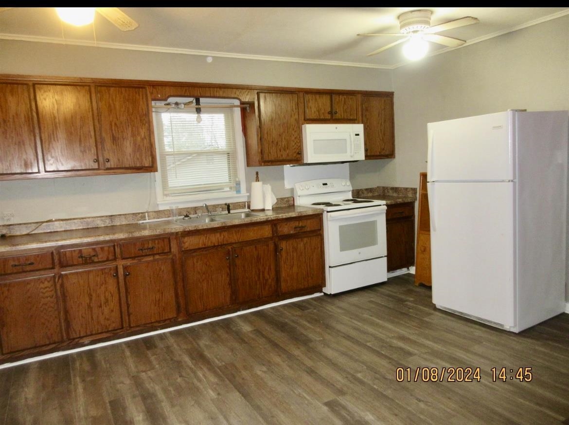 493 Perkins Street Ripley, TN 38063 - Photo 5 of 12 a kitchen with a sink cabinets and wooden floor