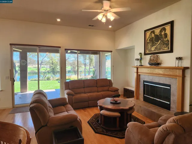a living room with furniture a fireplace and a large window